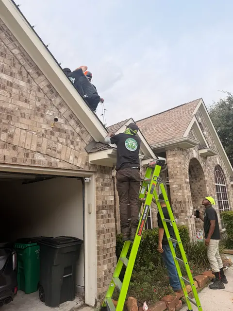 QuietScapes crew on ladders at a garage roofline