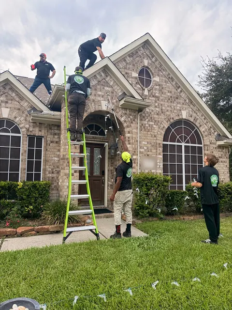 QuietScapes crew on ladders installing roofline lights
