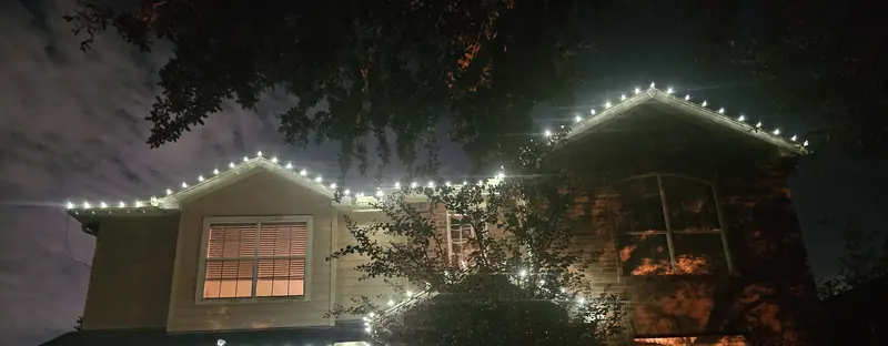 Two-story home with cool white roofline lights